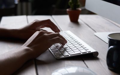 Close of hands of a person typing on a computer.